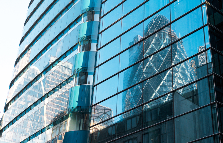 A tall spiralling architectural cone reflected in the glass of another building